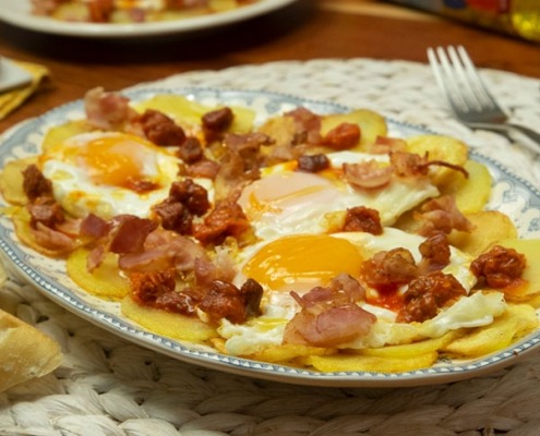 Patatas con huevos fritos, bacon, sobrasada y miel