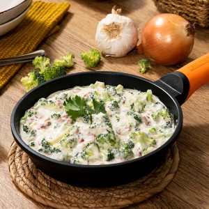 Brócoli con jamón en salsa cremosa, servido caliente en plato hondo