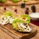 Tacos de lechuga con pollo, verduras y salsa de queso feta