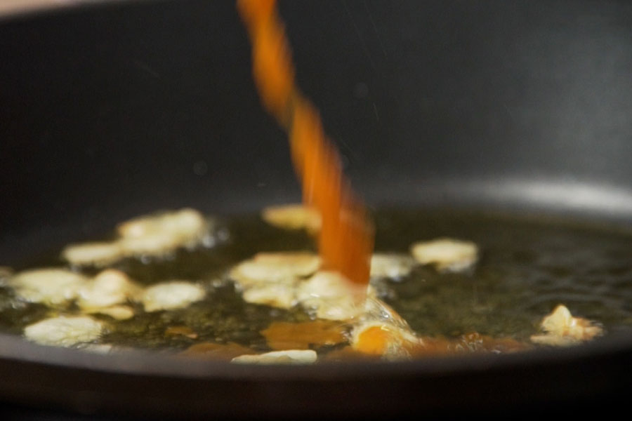 Receta casera de Gambas al ajillo y habanero. Doramos 4 dientes de ajo laminados en una sartén con aceite Excelentum La Masía y añadimos 1 cucharada de salsa de habanero Doctor Salsas