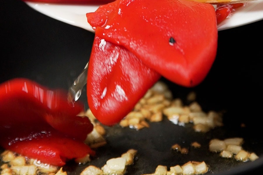Receta casera de Ensaladilla rusa con piquillos confitados. Confitamos 50 g de piquillos con ajo, azúcar y aceite de oliva virgen extra excelentum La Masía. Reservamos.