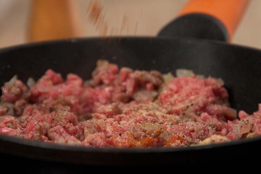 Receta casera de Tacos crujientes de carne. Cocinamos la carne picada con aceite de oliva Sumum La Masía, ½ cebolla picada, sal, pimienta, ½ cdta. de pimentón dulce y ½ cdta. de ajo en polvo. Reservamos.
