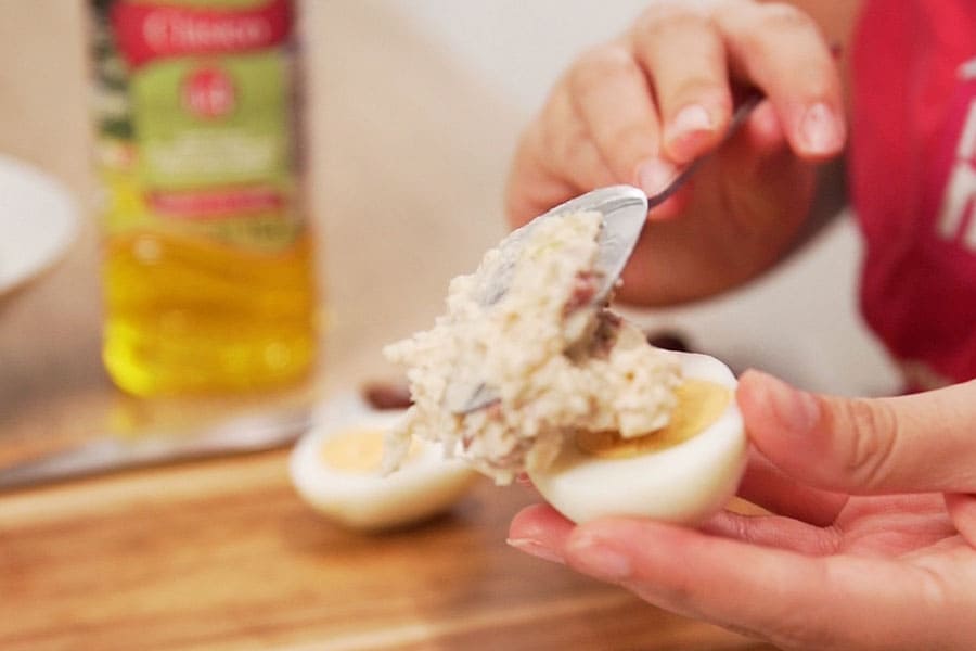 Receta casera de Croquetas de huevos rellenos de jamón. Cortamos los huevos cocidos por la mitad y los rellenamos con la bechamel.