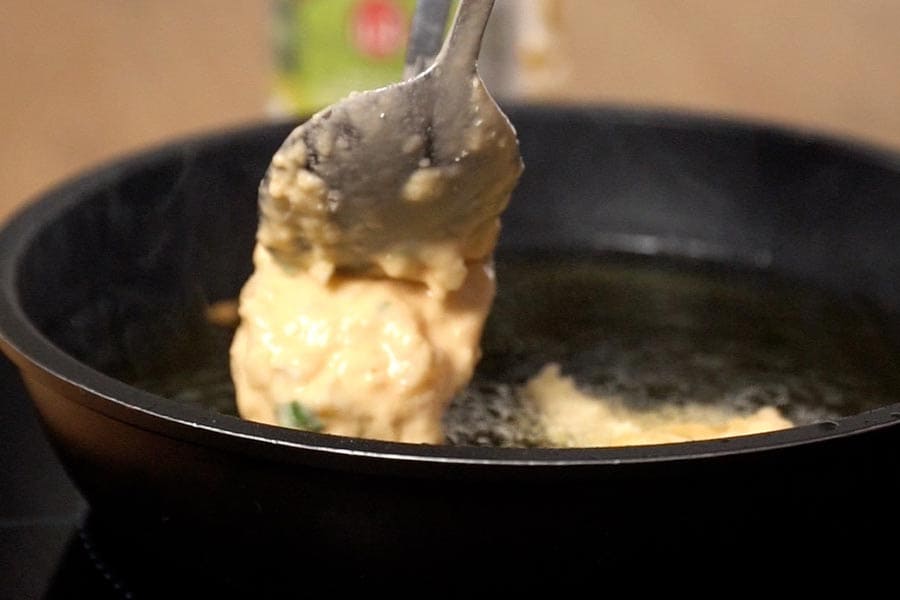 Receta casera de buñuelos de bacalao rellenos de mermelada de pimientos. Freímos los buñuelos en aceite de oliva Clásico La Masía.