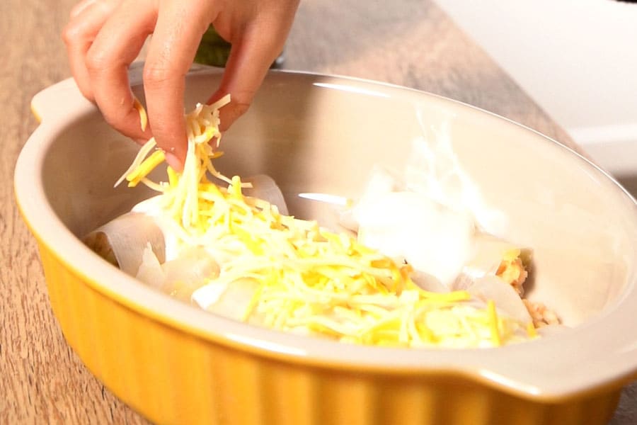 Receta casera de Canelones de puerro rellenos de merluza y gambas. Montamos los canelones y los gratinamos al horno
