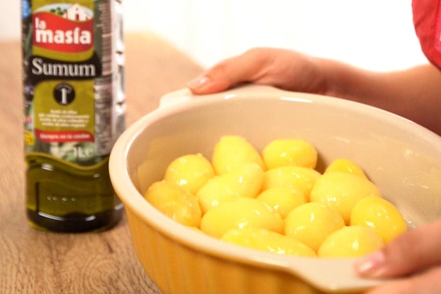 Patatas en una fuente de horno con aceite de oliva sumum, listas para acompañar el pollo en salsa gratinado con setas.