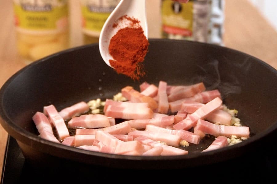 Receta casera de judías salteadas, patatas huevos, bacon. Cocinamos el bacon con Aceite de Oliva Sumum La Masía, ajo y pimentón.