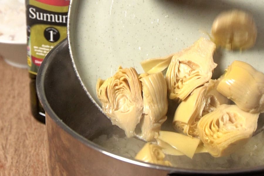 Receta casera Guiso de sepia con alcachofas. Sofreímos la cebolla y alcacahofas con aceite de oliva Sumum La Masía