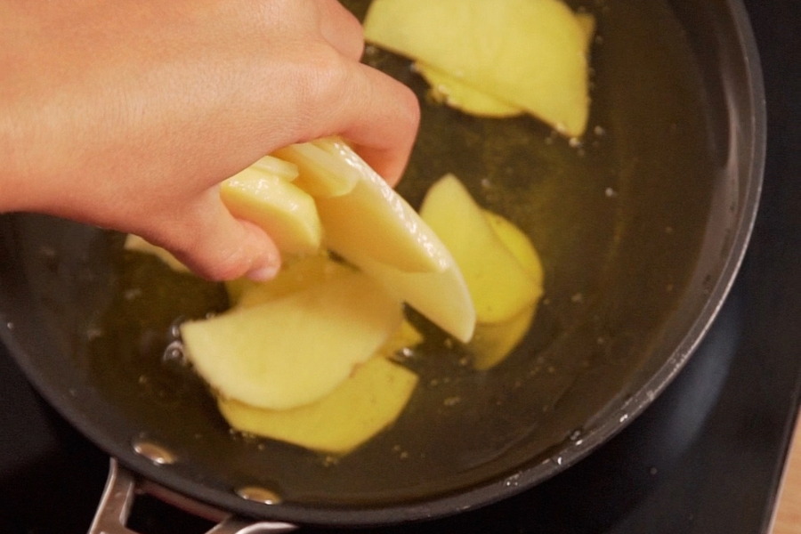 Receta casera de croquetas de tortilla de patatas. Freimos las patatas en aceite de oliva sumum la masía