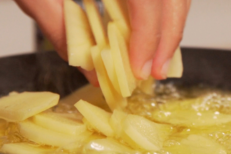 Receta casera de Papas esparragás. Freimos las patatas en aceite de oliva Sumum La Masia
